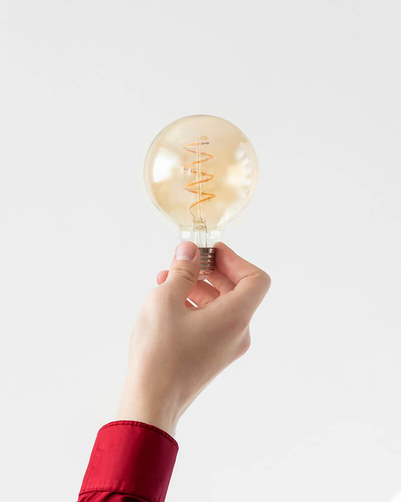 close-up-hand-holding-light-bulb